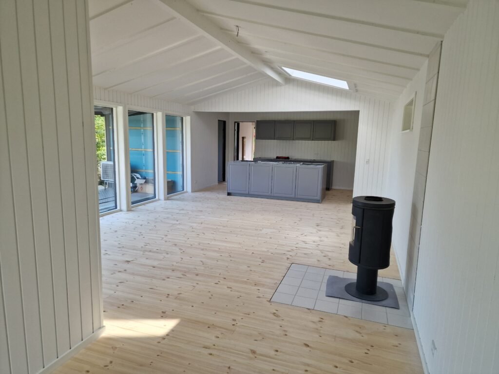 Lyst moderne køkken og stue med brændeovn