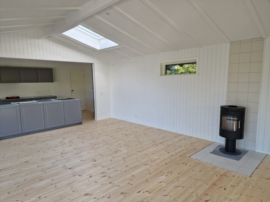 Lyst køkkenalrum med brændeovn og ovenlysvindue