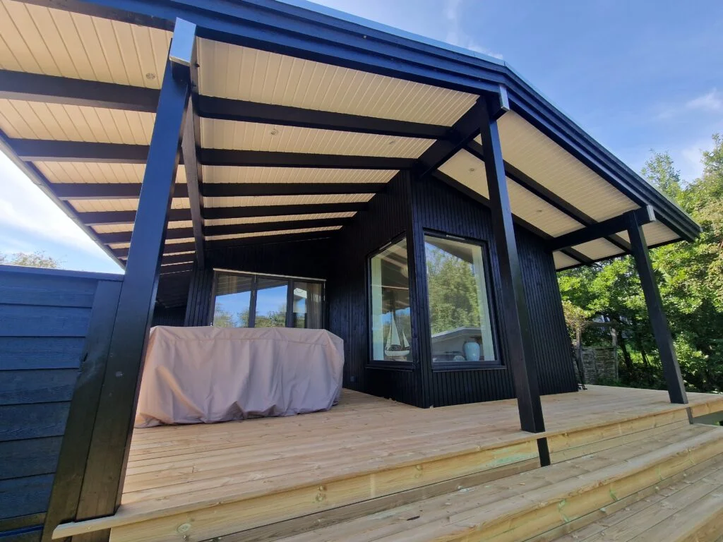 Moderne sort træhus med overdækket træterrasse