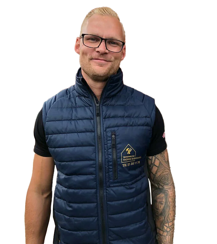 Mand i arbejdstøj med logo og tatoveringer