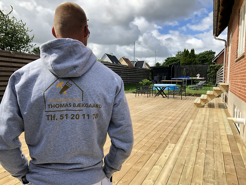 Tømrer på nybygget træterrasse ved murstenshus